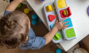 Dziecko bawi się zabawką edukacyjną. Zastanawiasz się, ile kosztuje żłobek miesięcznie?