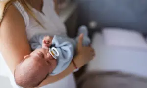 Mama tuli otula noworodka ze smoczkiem. Czy dziecko może spać ze smoczkiem? To pytanie nurtuje wielu rodziców.