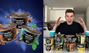 Mężczyzna z otwartymi ustami i rękami w górze, otoczony przez wiele kubków puddingu proteinowego.