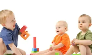 Trzy maluchy bawią się klockami. Zastanawiasz się, ile można zarobić na żłobku?