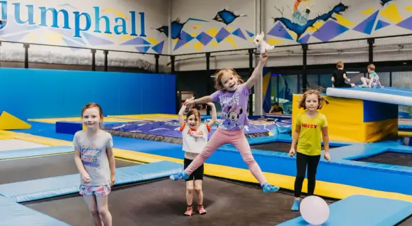 Dzieci skaczą na trampolinach w sali zabaw. Czy trampolina jest zdrowa? Zdecydowanie tak, to świetna zabawa i aktywność fizyczna!