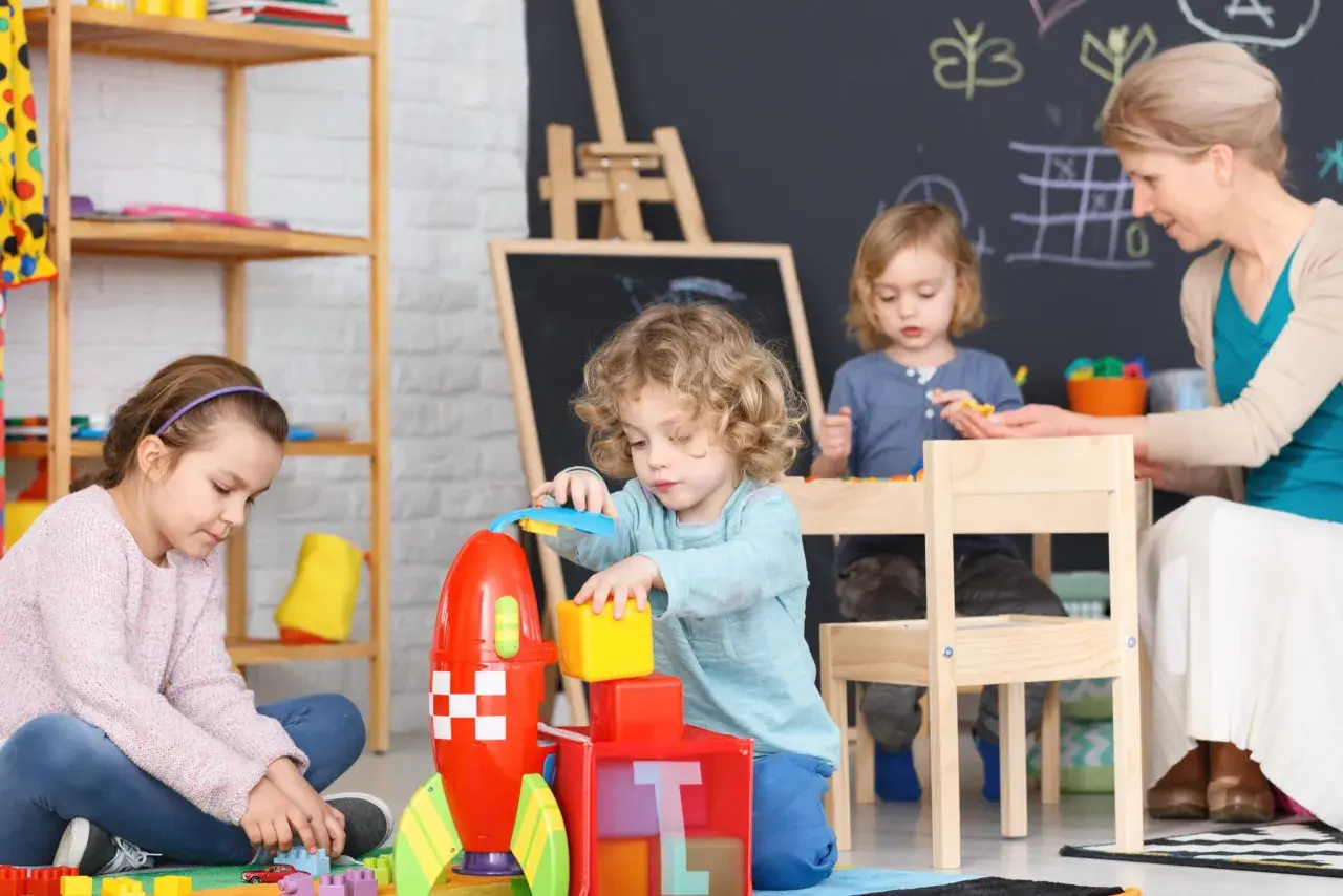 Dzieci bawią się klockami w żłobku. Zastanawiasz się, ile zarabia się w żłobku prywatnym?