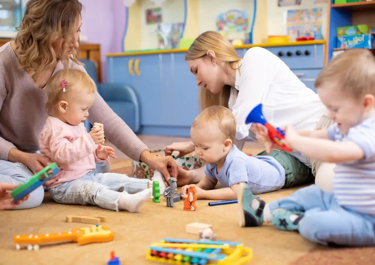 Dzieci bawią się zabawkami w żłobku. Zastanawiasz się, ile zarabia się w żłobku prywatnym?