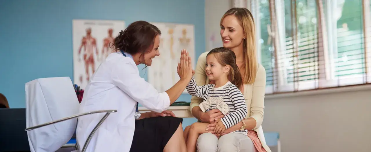 Lekarka daje piątkę dziecku, które przyszło z mamą do gabinetu. Miła atmosfera, kiedy z dzieckiem do psychiatry.
