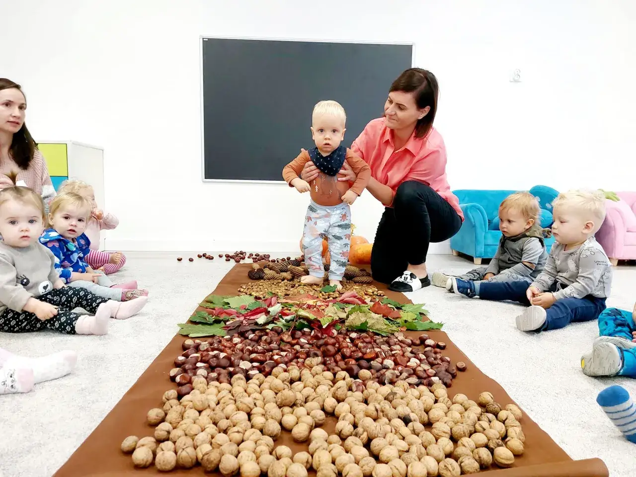 Dzieci i opiekunki na zajęciach sensorycznych z orzechami i kasztanami. Czy żłobek to dobry pomysł? Tak, gdy jest tak ciekawie!