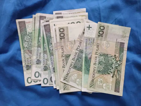 Stos stu-złotowych banknotów. Zastanawiasz się, ile można przelać z konta dziecka?